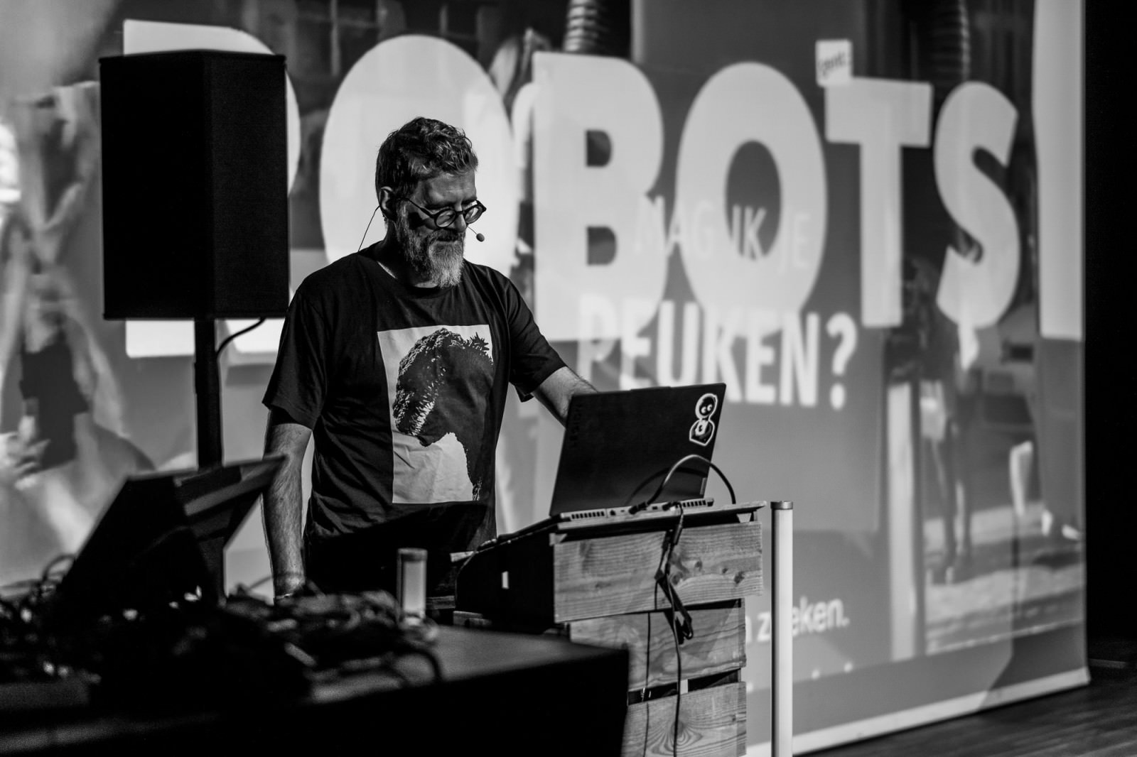 A black and white photo of Jan De Coster on stage at beyond tellerrand in Berlin