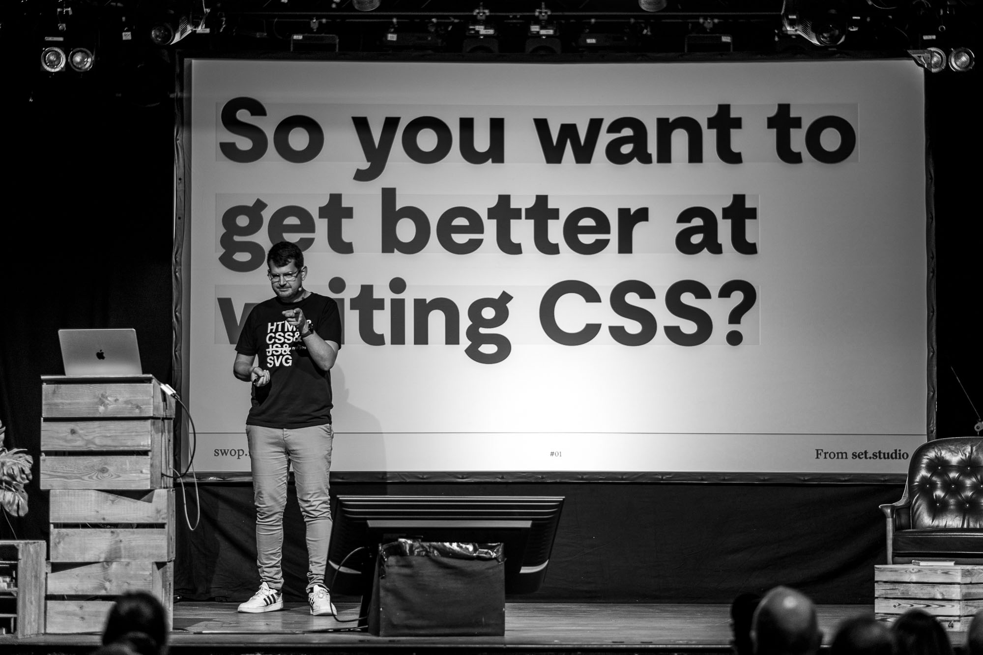 Andy Bell on stage at beyond telelrrand with a photo taken straight from the front. You see andy pointing to you, the one watching him, and a slide say in bold, black letters “So you want to get better at writing CSS?”