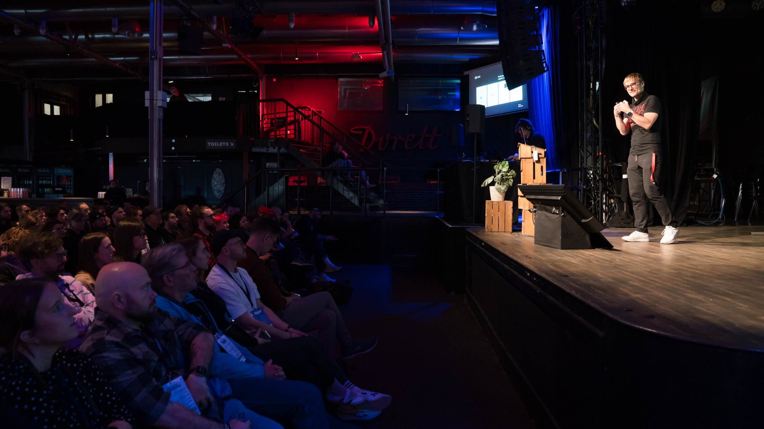 A photo from the side of the stage woth Thorsten Jonas on stage at beyond tellerrand. You can see him on the right and a full room on the left.