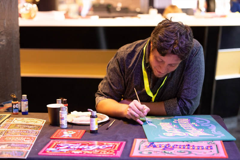 Gustavo Ferrari painting a sign stating “beyond tellerrand”