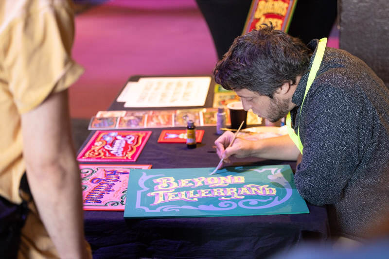 Gustavo Ferrari painting a sign stating “beyond tellerrand”