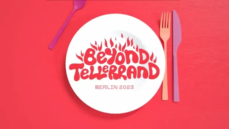 One screen of the opening titles for Berlin 2023 and you can see a white plate on a read background, an orange fork and violett knife on the right next to it and a dark violett spoon on top left above it. On the plate it states “beyond tellerrand Berlin 2023 in red letters.