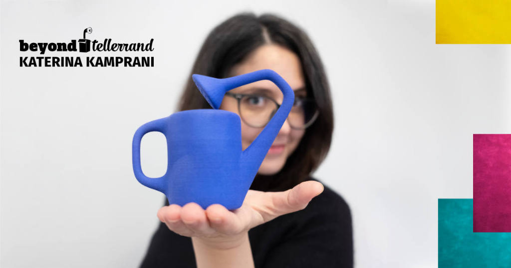 Katerina Kamprani speaker profile picture on which she is looking through one of her art pieces, which seems to be an unusable watering can with the spout facing backwards.