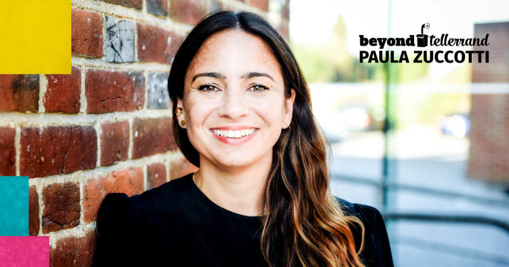 A portrait of Paula Zuccotti in front of brick wall