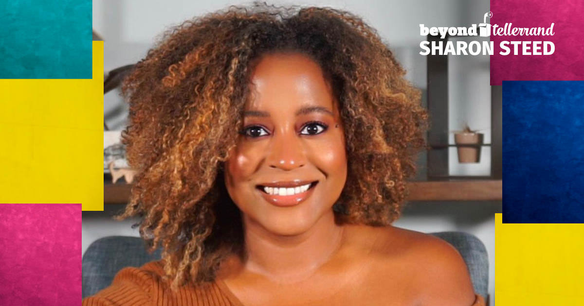 A portrait of Sharon looking straight into the camera, smiling wonderfully.