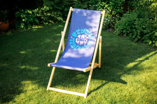 you see a beach chair on lawn and the beach chair also has the design that Mark Caneso originally crafted for the t-shirts