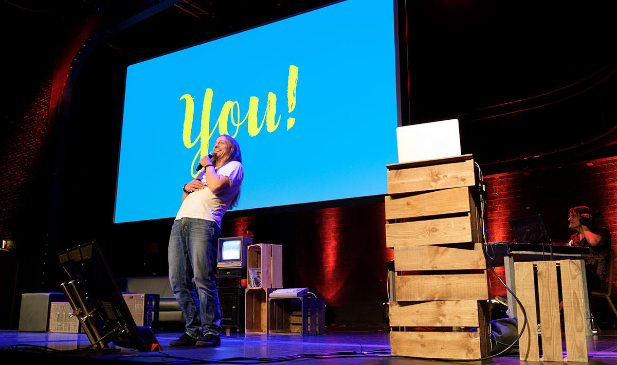 Marc Thiele on stage with a slide saying “you!”