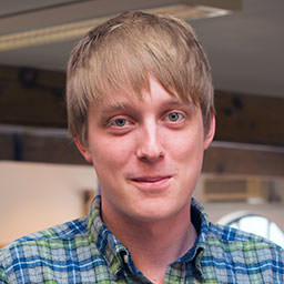 A headshot of James Hall looking straight into the camera