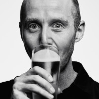 A photo with a portrait of Mike Hill drinking a beer