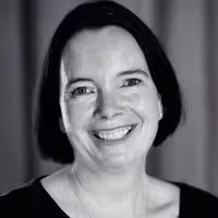 Portrait photo of Sacha Judd. She is looking into the camera and has a big smile on her face. Her head is lightly tilted to the left.