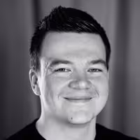 A portrait of Manuel ﻿Matuzović. He sits slightly tilted to the left and has a charming grin on his face.