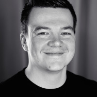 A portrait of Manuel ﻿Matuzović. He sits slightly tilted to the left and has a charming grin on his face.